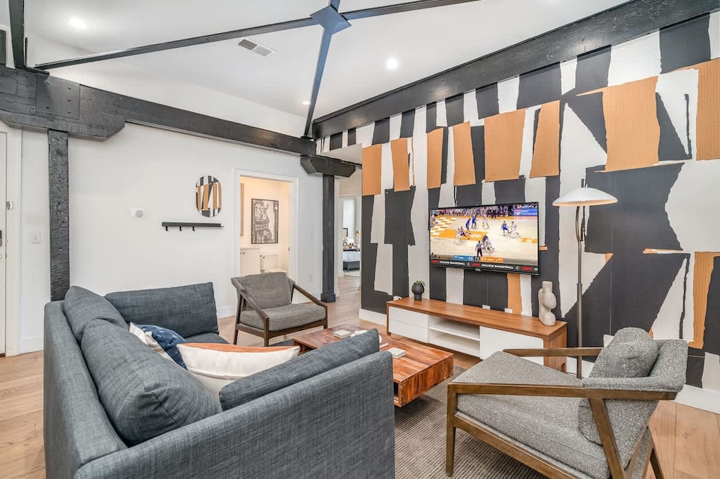 Unit 3: Open-concept living area featuring cozy furnishings, smart TV, and a sleeper sofa. (5th Floor)