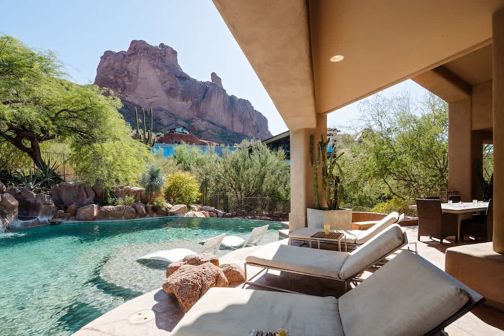 Resort-style backyard with a sparkling pool, waterslide, hot tub, sun loungers, private patio a beautiful view of the scenery.