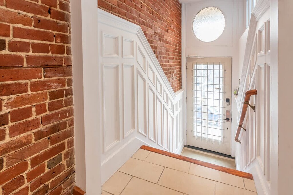 Stylish staircase accented by a rustic brick wall for added character and warmth.