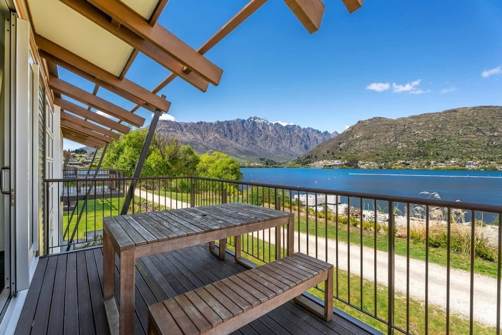 Private balcony with outdoor dining, overlooking the lake and surrounding mountains