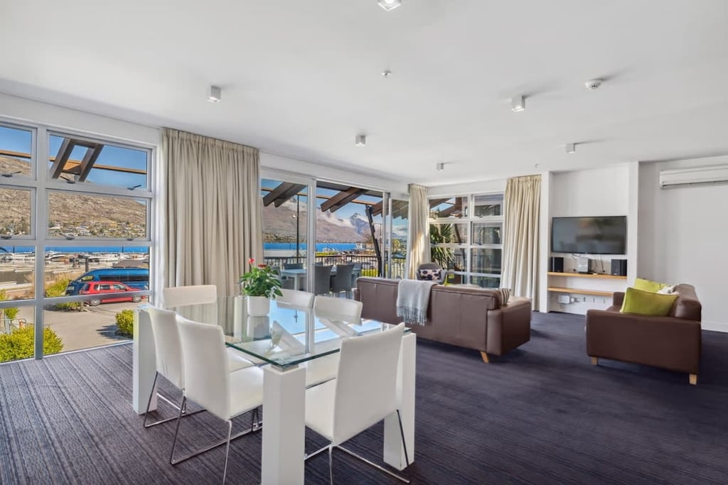 Stylish dining setup beside floor-to-ceiling windows
