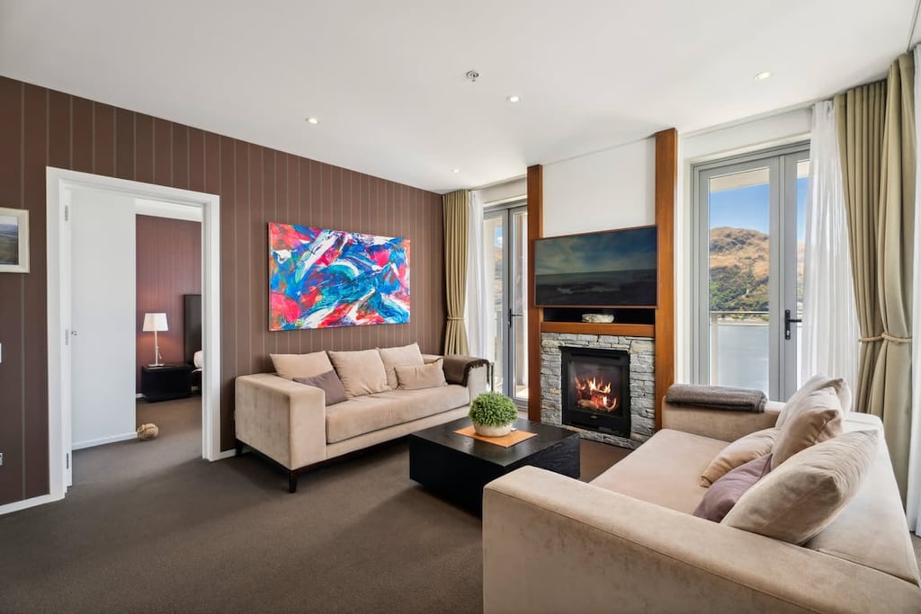 A delightfully cozy living room with spectacular views over Lake Wakatipu and the surrounding mountains.   The huge outdoor deck is north facing, so enjoys plenty of sunshine all day long.