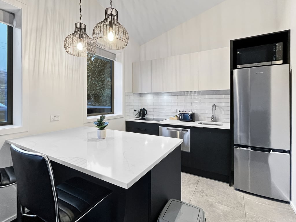 Fully equipped kitchen with modern appliances and breakfast bar seating.