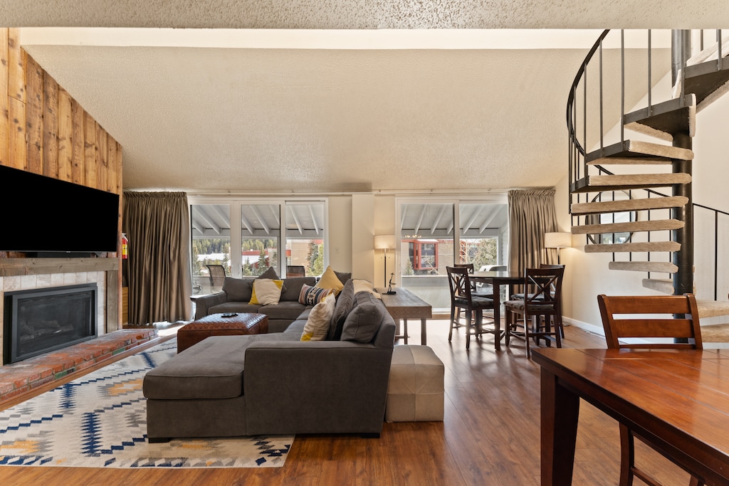 Relax in your spacious living area with plush seating, cozy fireplace, and spiral staircase leading to your private loft retreat.