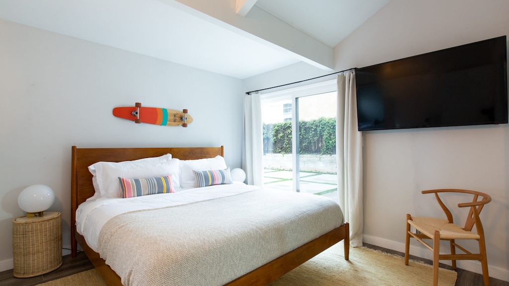 The primary bedroom features an ensuite, TV, and outdoor access.