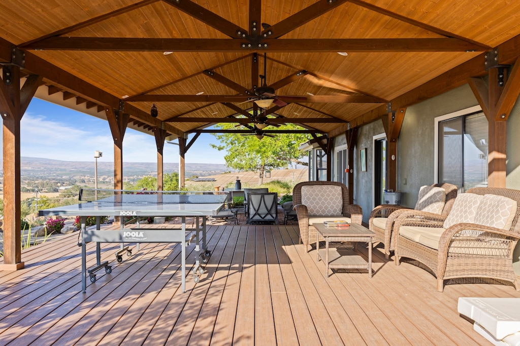 Spacious patio features an outdoor dining table and a ping pong table.