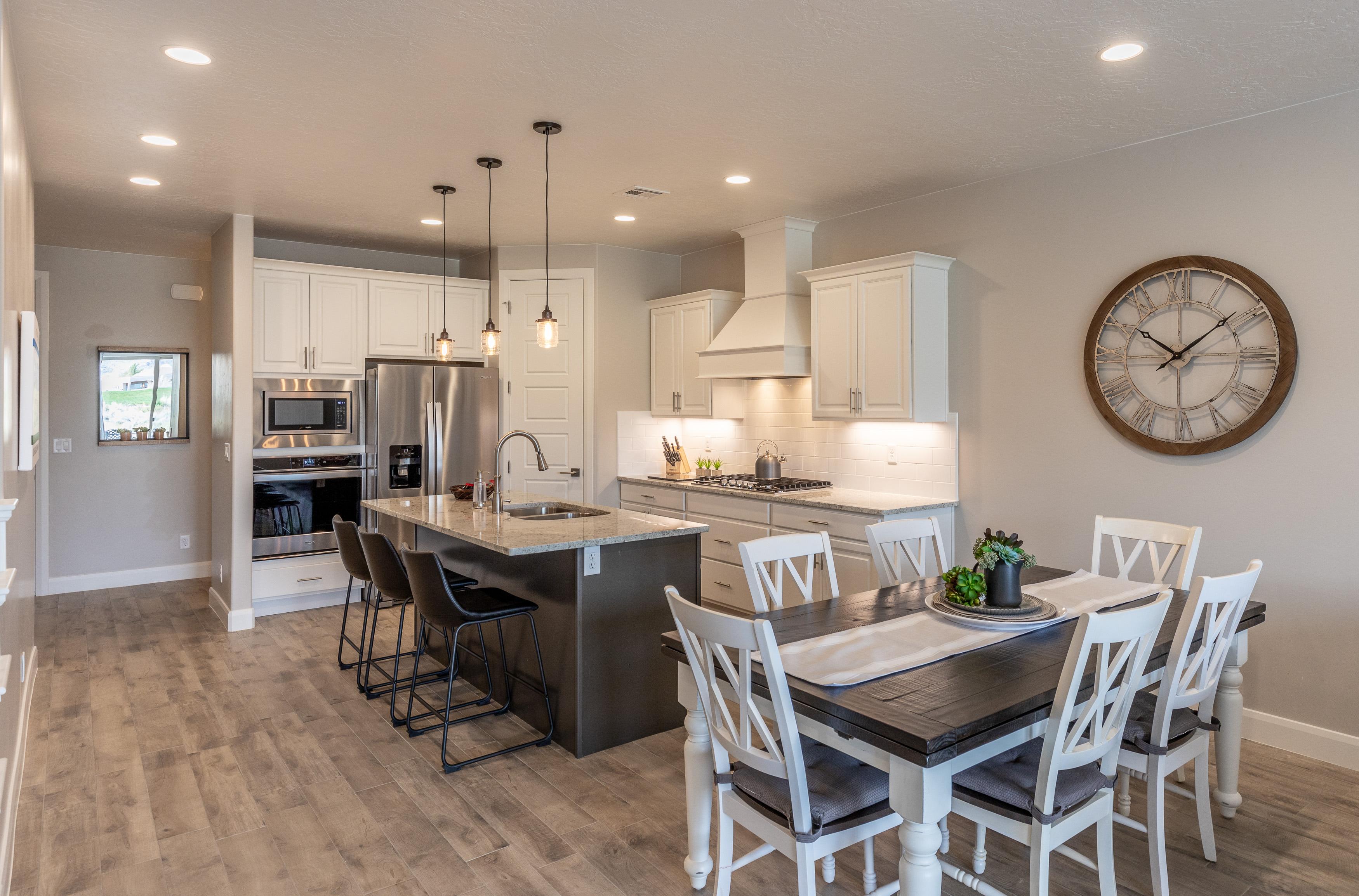 The Kitchen and Dining Table can accommodate 9 adults and is stocked with pots, pans, baking sheets, mixing bowls, plates, bowls, cups, silverware, and a collection of cooking utensils.
