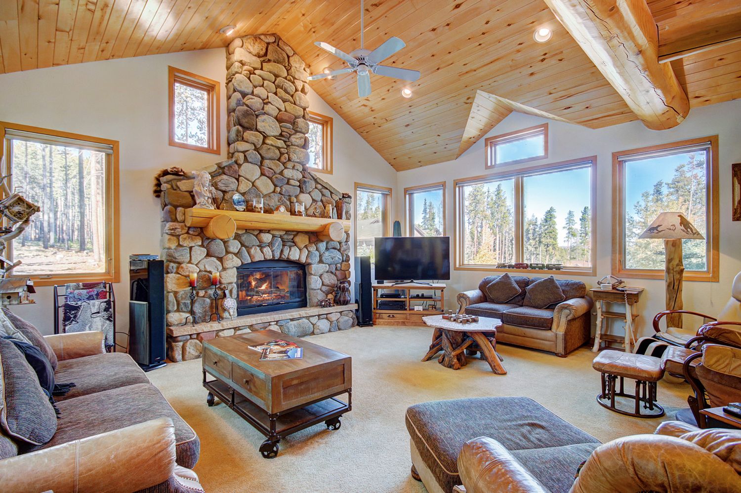 Beautiful living room with gas fireplace, flat screen TV, and large windows - 