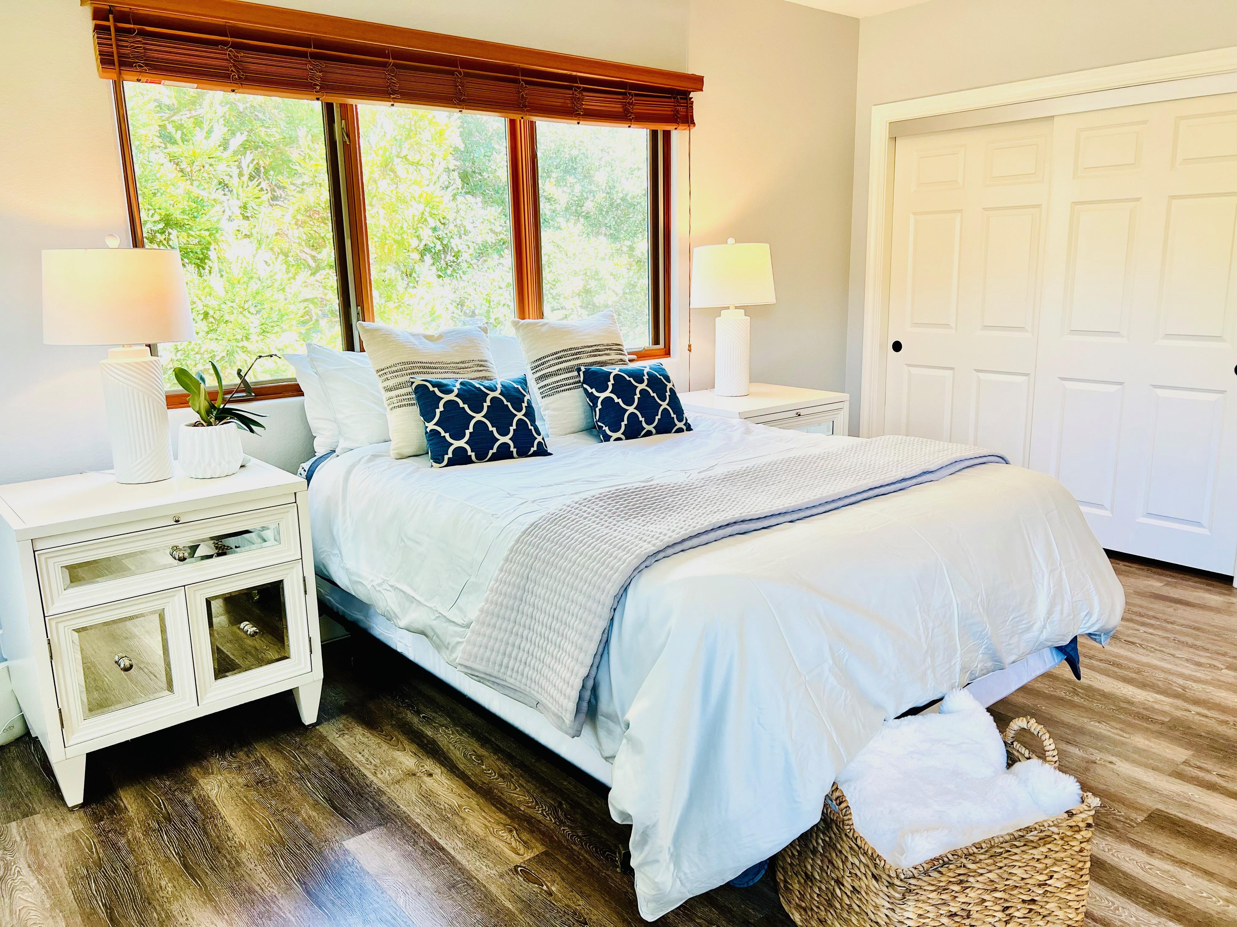 The master suite features a queen bed, his and hers closets, and a connected bathroom with double sinks, tub, and shower. 