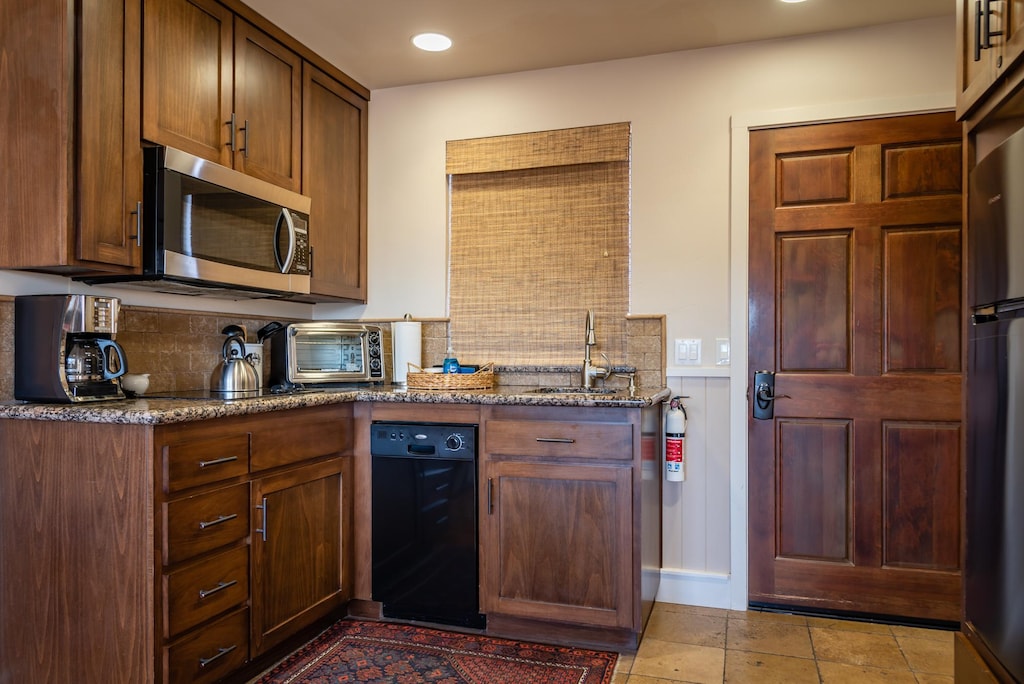 An apartment-style kitchen with dishwasher, refrigerator, and co