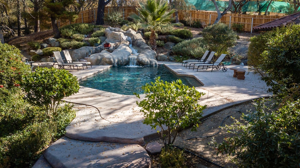 A lovely waterfall runs down a natural rock formation into the pool, which is more than inviting.