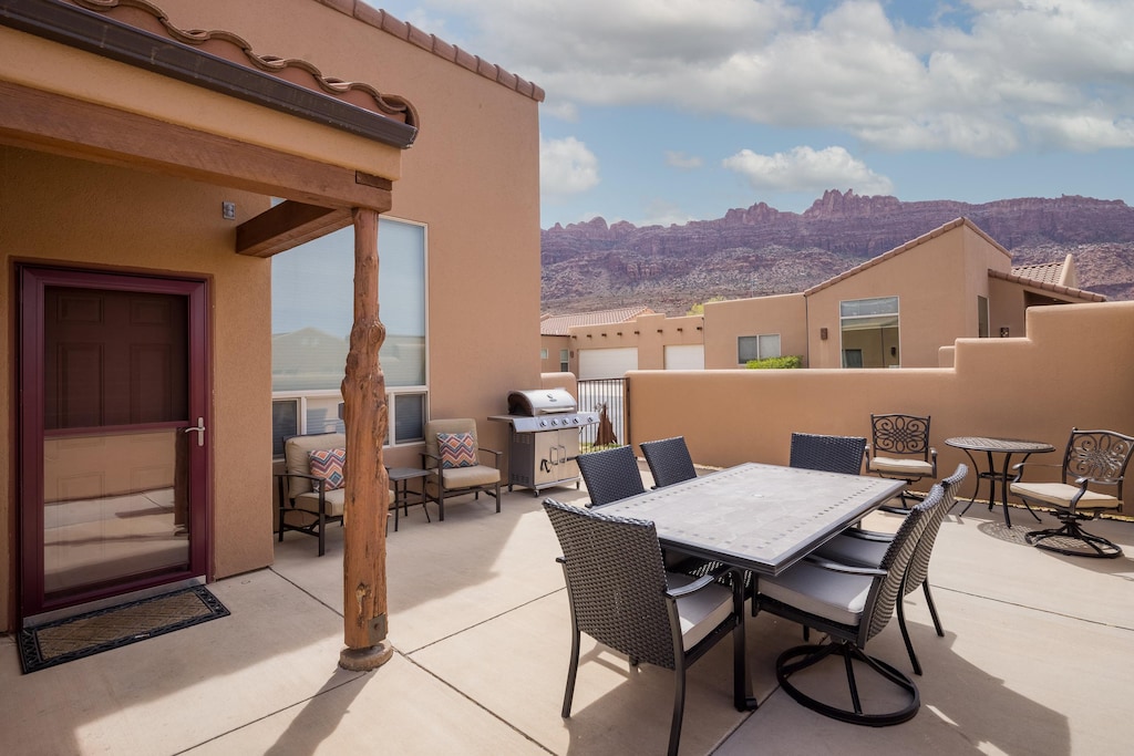 Spacious, enclosed patio with dining and seating areas, a gas grill, loungers and a private hot tub!