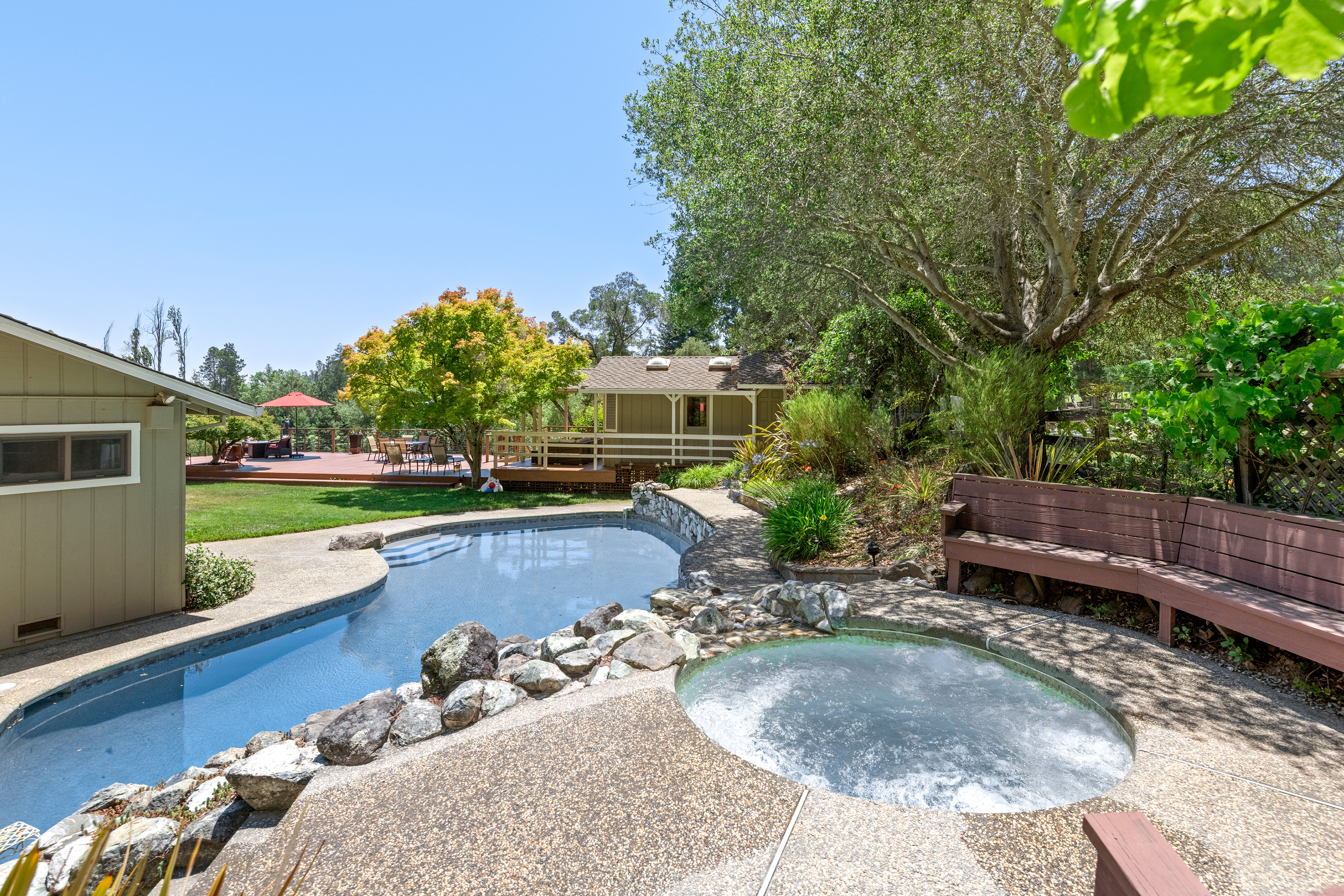 Like an oasis, the hot tub (avail. yearround) overlooks the pool, lawn, and deck.