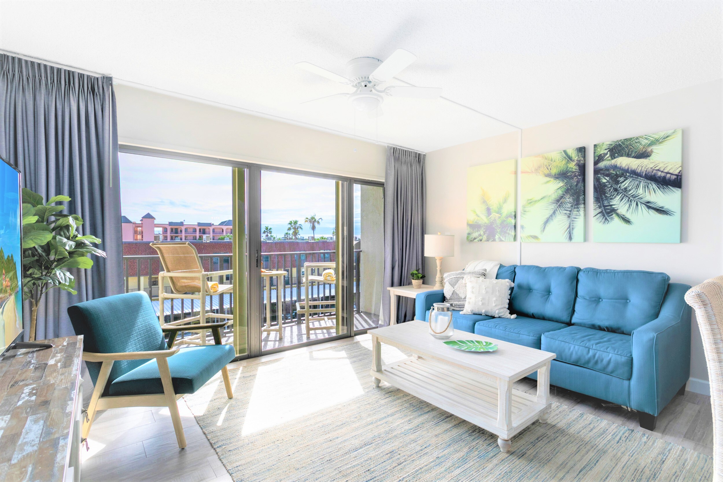 Relax in this coastal casual beach condo - living room walks out onto patio and has a 65" TV and sleeper sofa.