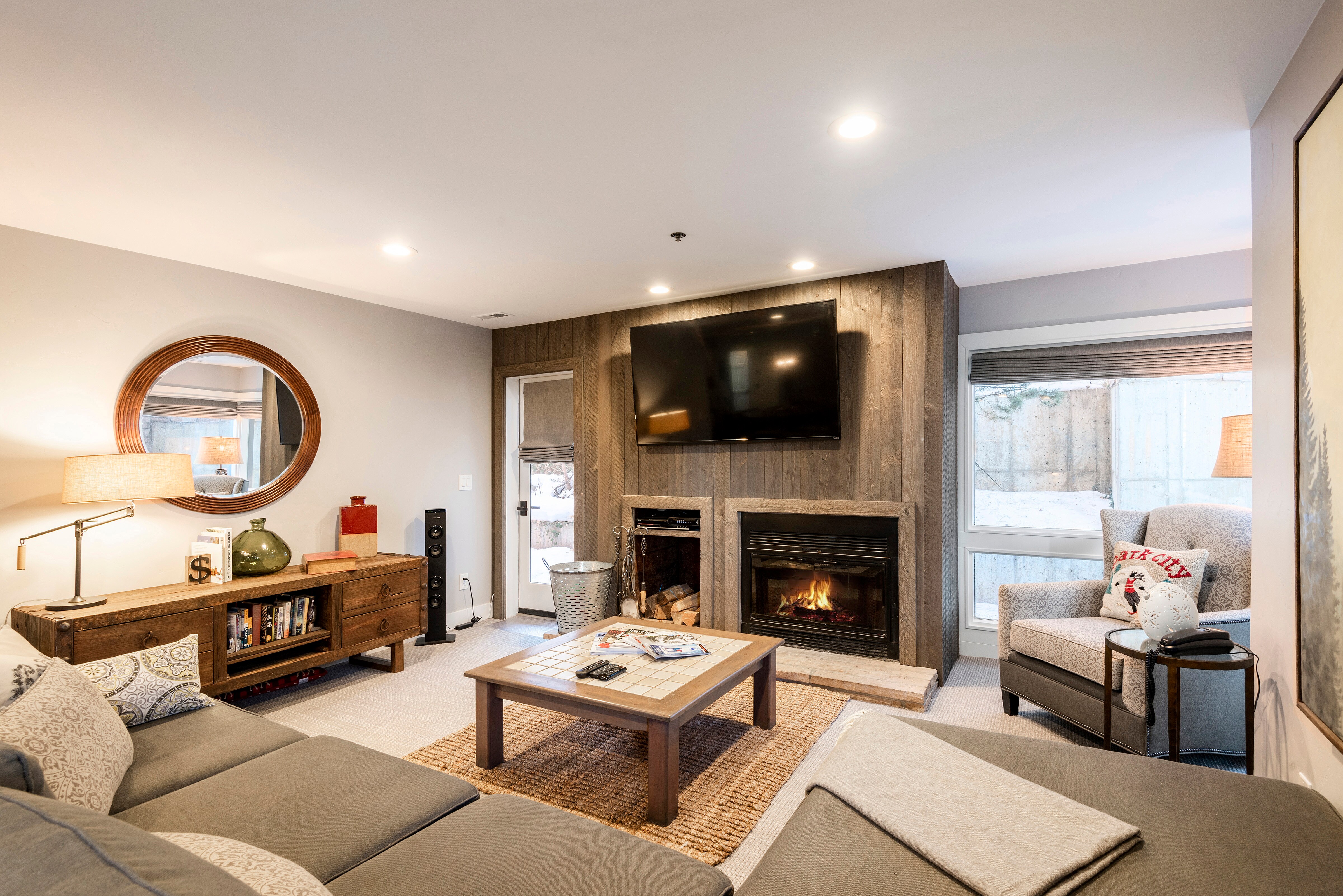 Living Room with 65" Smart TV, Wood Burning Fireplace, Patio Access, and Mountain Contemporary Furnishings