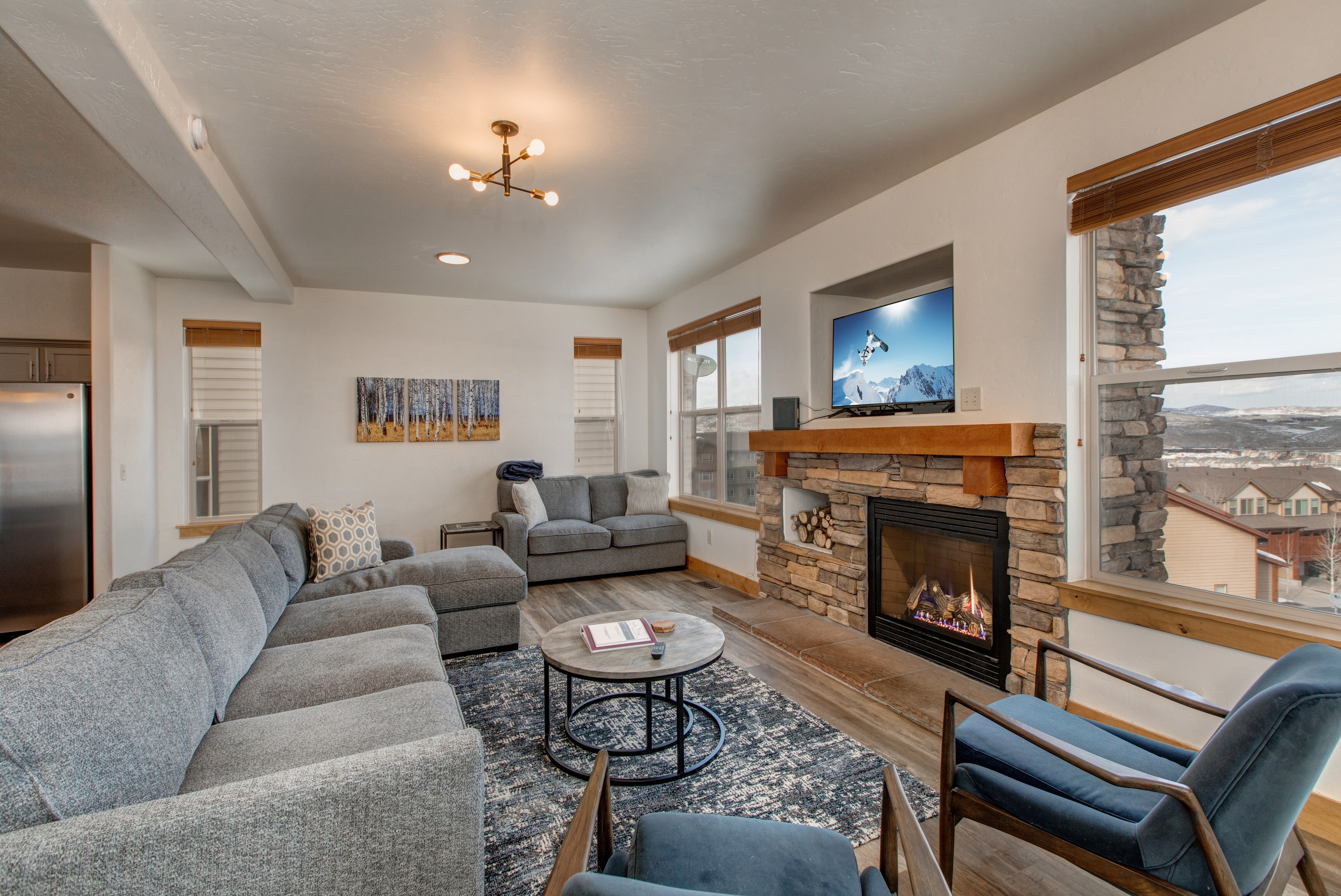 Main Level Living room with ample seating throughout the large sectional sofa, plush loveseat and two contemporary chairs. A gas fireplace, 50" Samsung smart tv, and private deck access make this the perfect room to gather and spend a night in