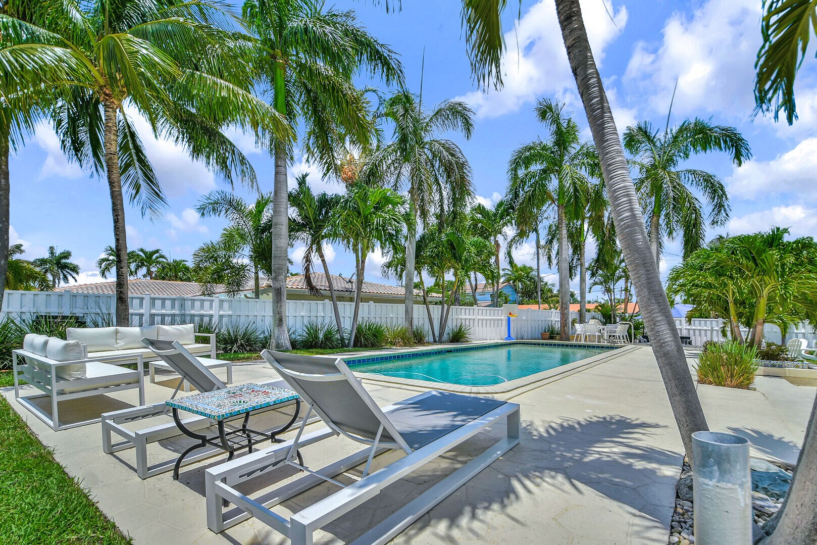 Sun loungers and palm trees surround the heated pool