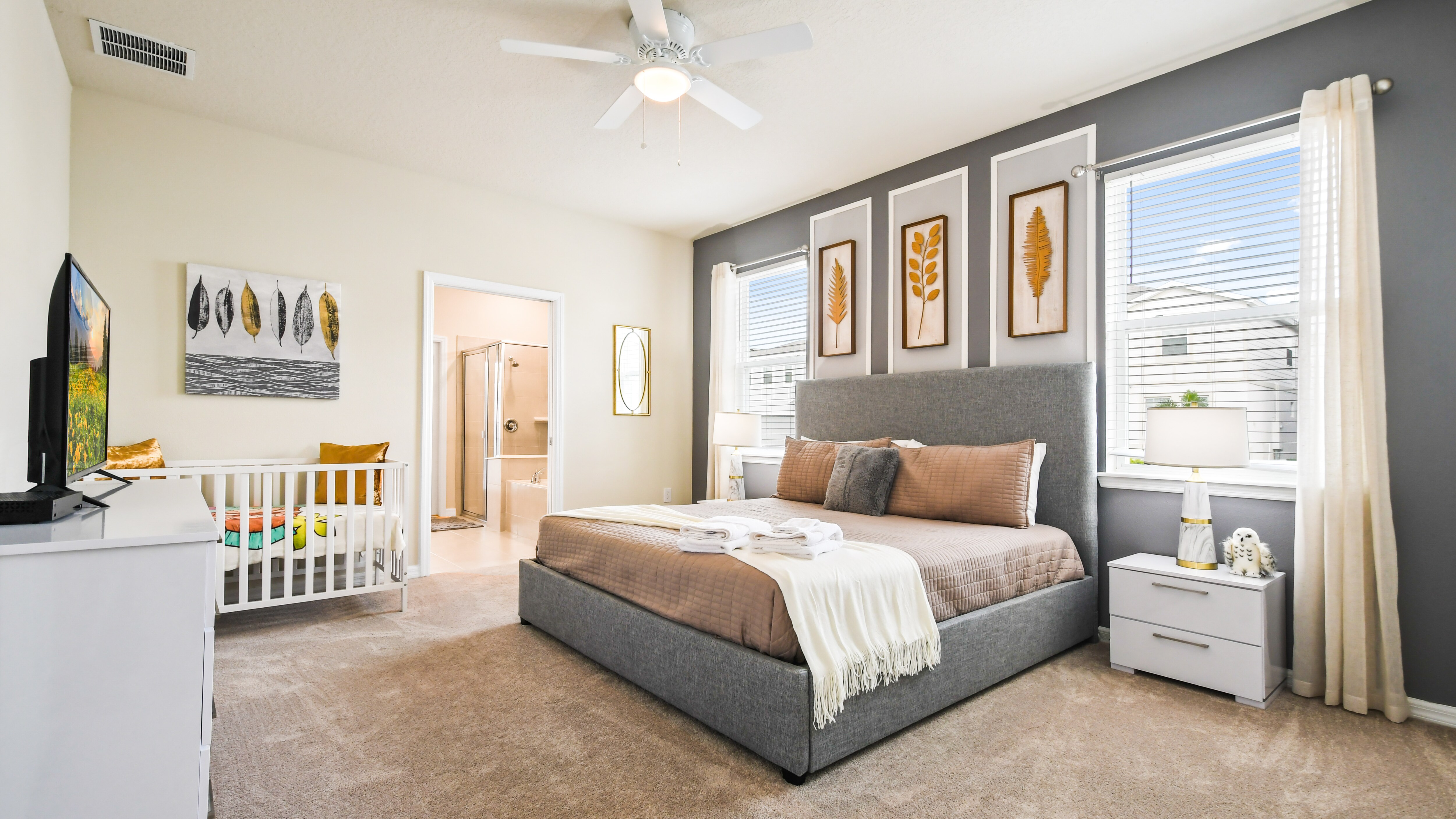 The master bedroom features a luxuriously large king bed with a crib